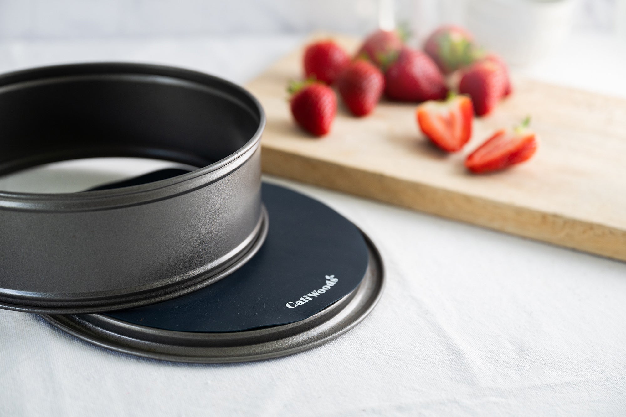 Reusable cake tin liners with strawberries in the background