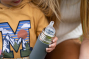 CaliWoods kids stainless steel water bottle with son and Mum in the background