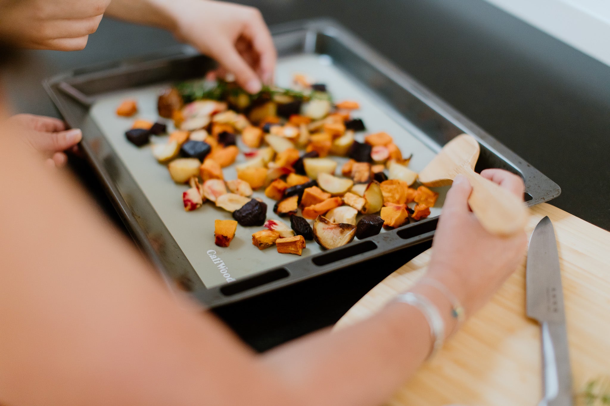 Green Reusable Baking Mat with roast veges on a tray