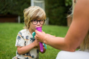 reusable ice block moulds being used by a blonde boy on the grass