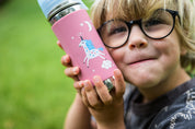 Pink Unicorn toddler stainless steel water Pura bottle from CaliWoods held in hands of little boy with glasses