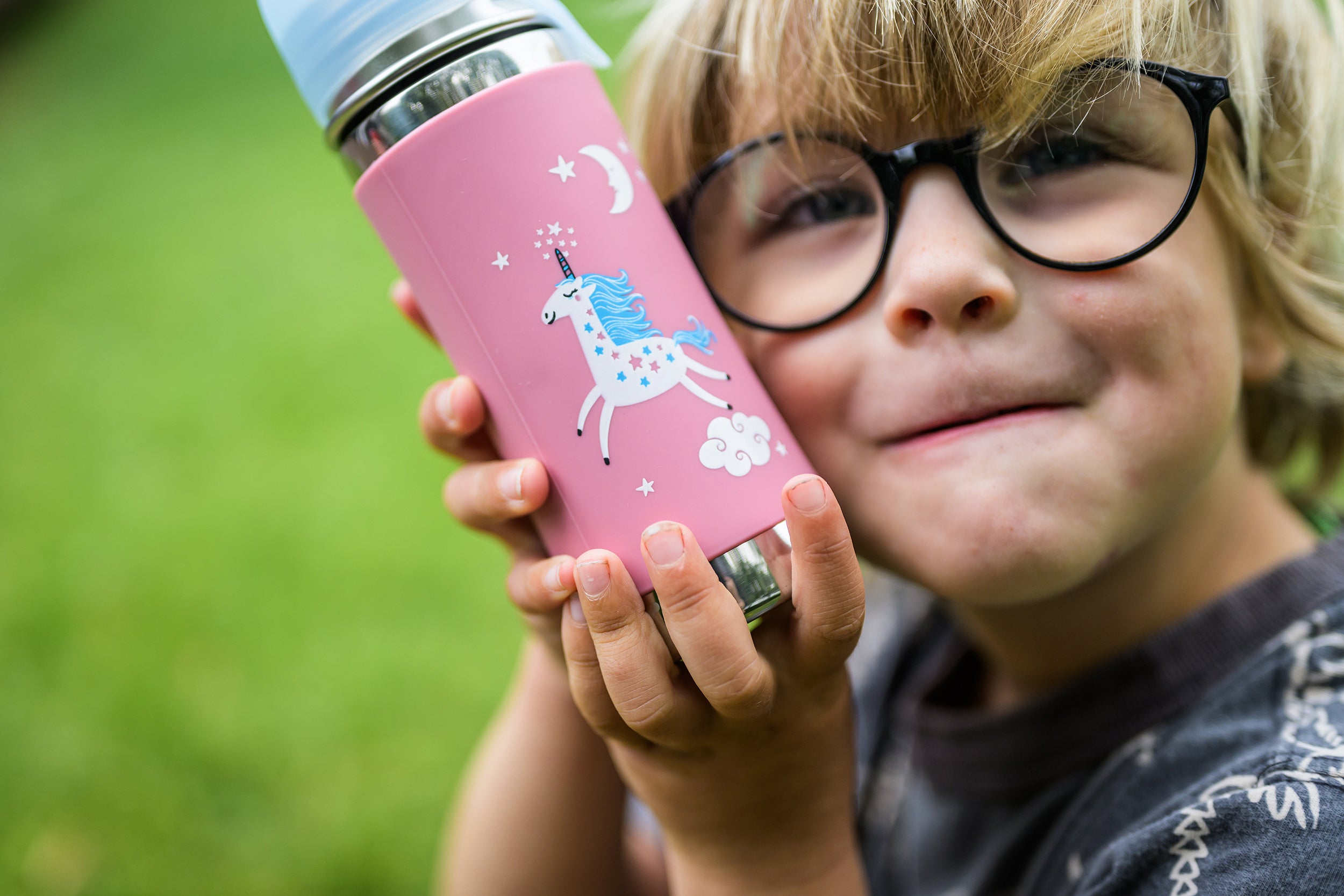 Pink Unicorn toddler stainless steel water Pura bottle from CaliWoods held in hands of little boy with glasses