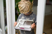 Young boy in doorway holding a CaliWoods Stainless Bento Lunchbox