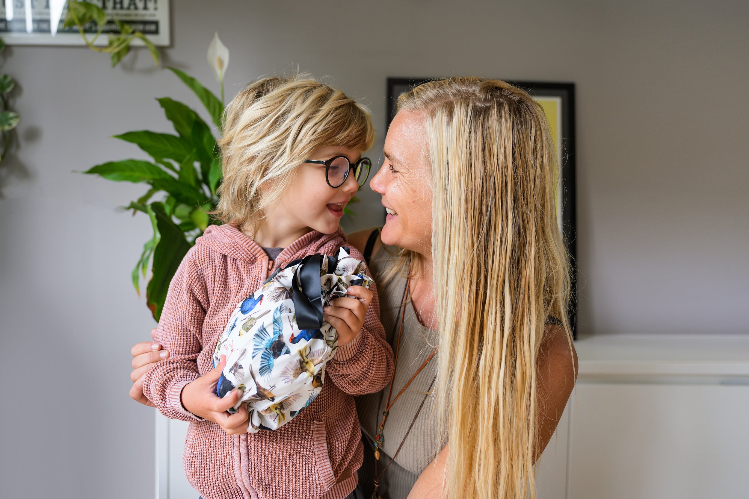 Mum and son smiling at each other while boy holds a CaliWoods reusable gift bag