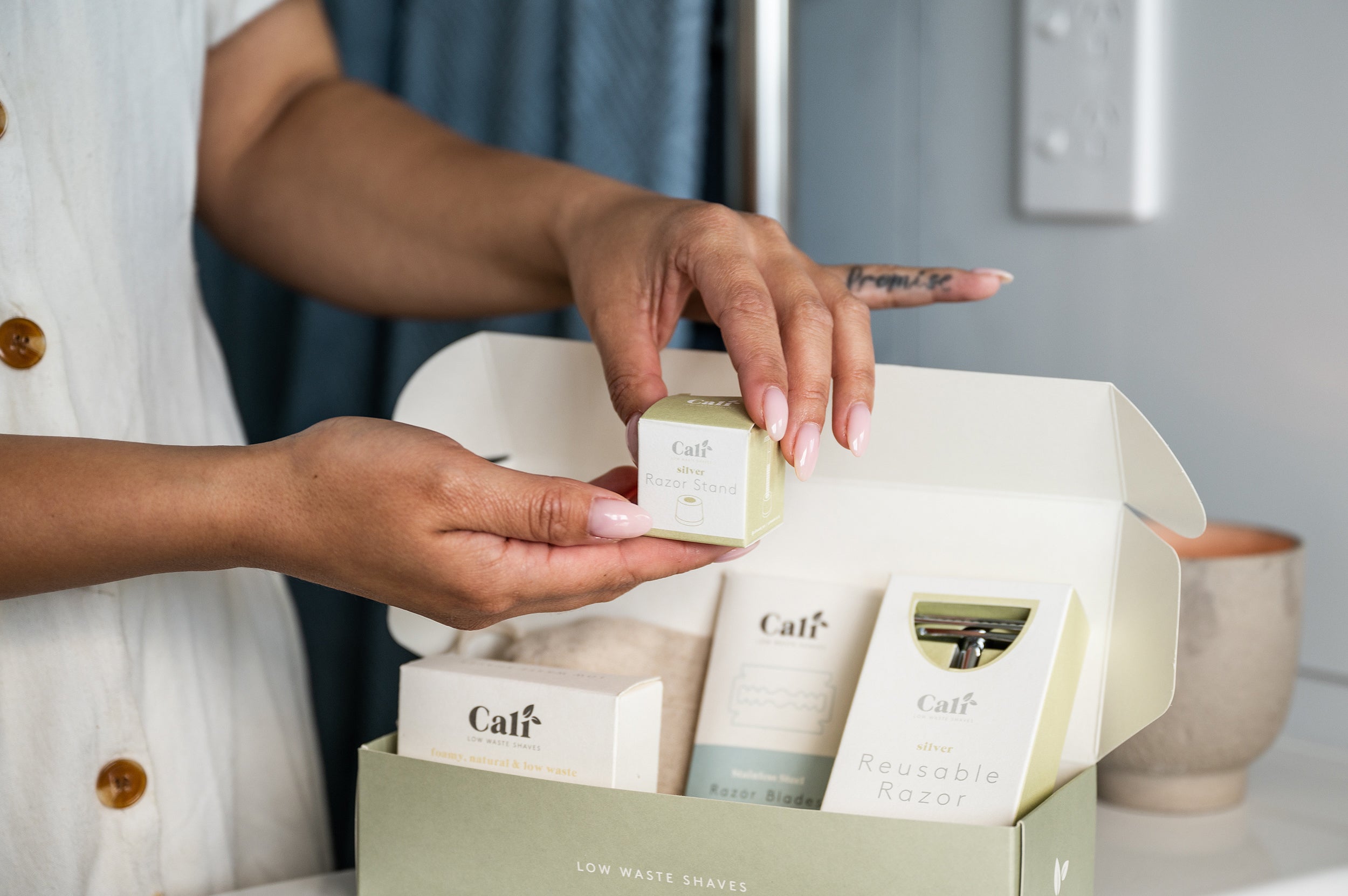 The silver Safety Razor stand held in hands above the CaliWoods zero waste Shaving Kit