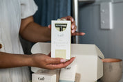 Hands holding the silver Safety Razor with the CaliWoods Safety Razor Shaving Kit in the background