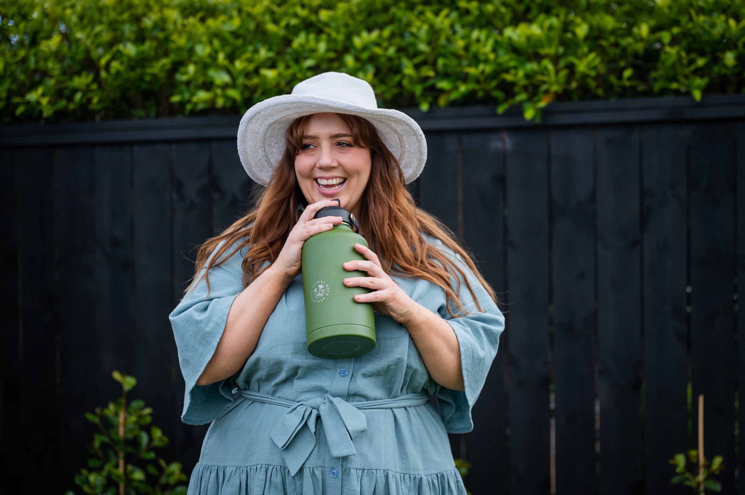 Woman laughing and drinking from CaliWoods drink bottle