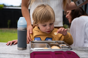 Child eating crackers out of stainless steel lunch box 