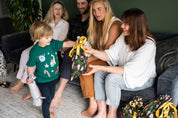 Little boy receiving Christmas gift in a reusable gift bag