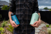 Man holding two stainless steel drink bottles in his hands