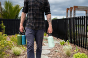 Man walking and holding 3 Dawny CaliWoods water bottles 