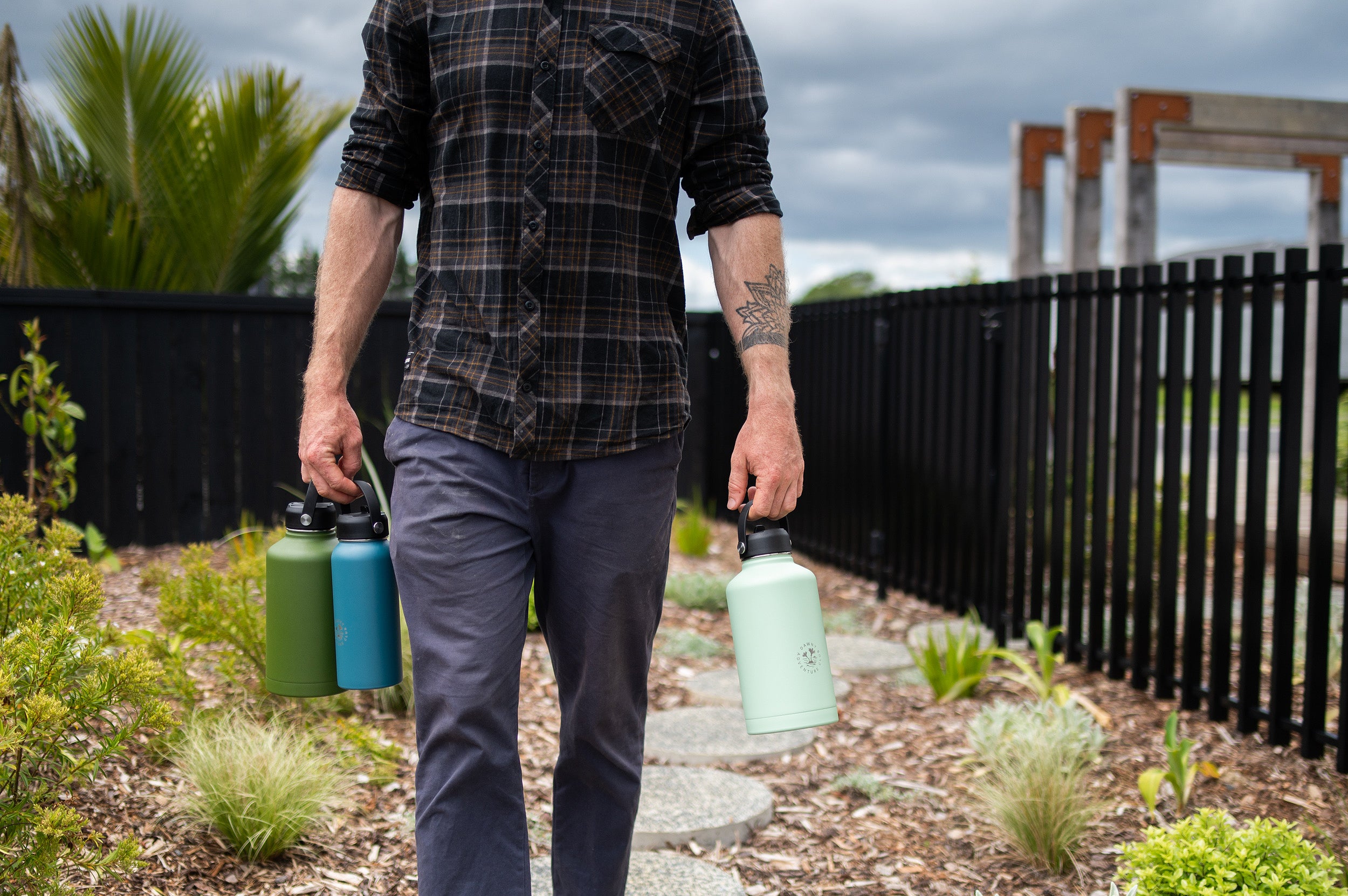 Man walking and holding 3 Dawny CaliWoods water bottles 