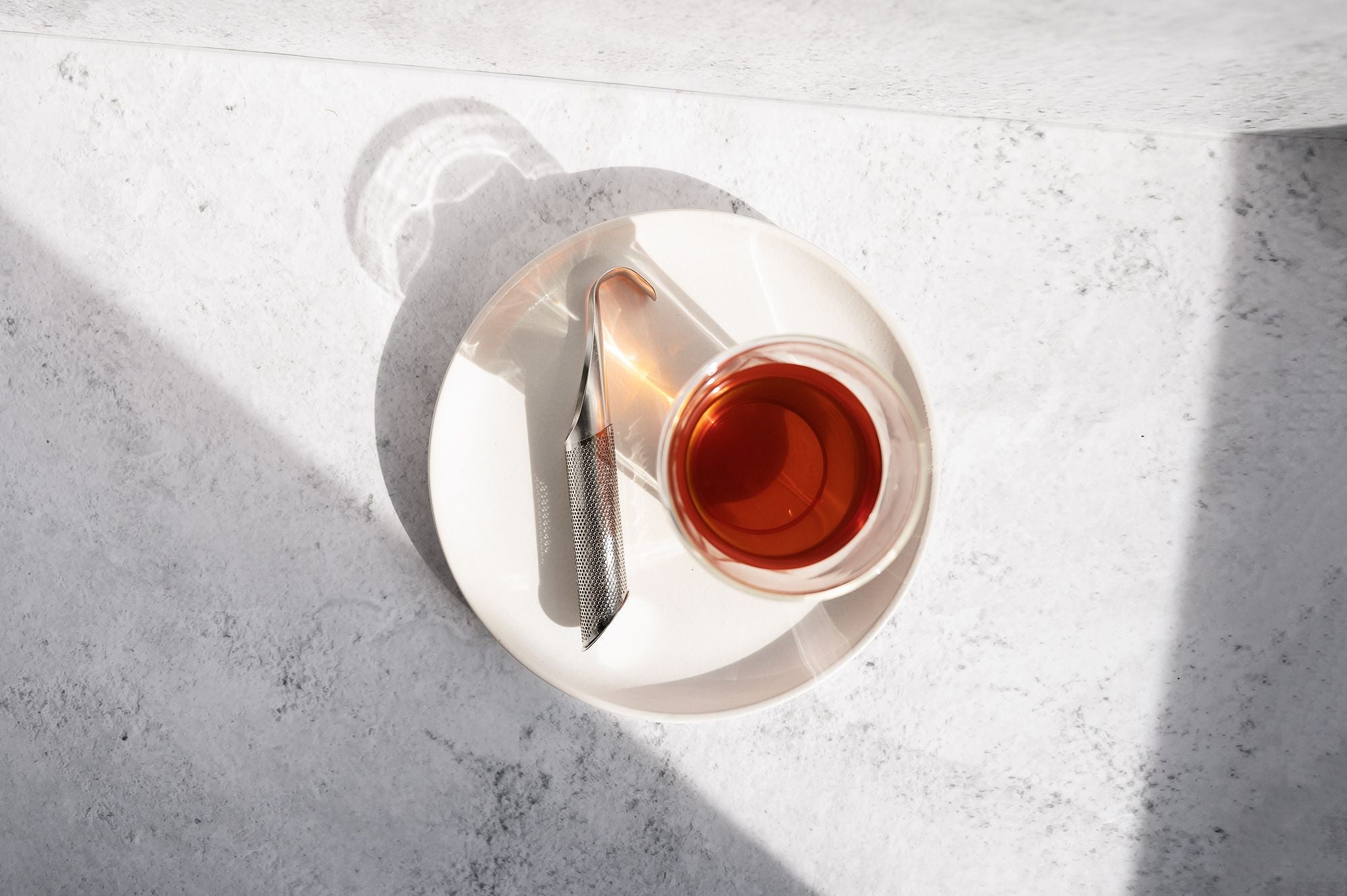 Birds eye view of a cup of tea with a Tea Infuser next to it