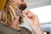 Silver stainless steel Safety Razor against a man's neck 