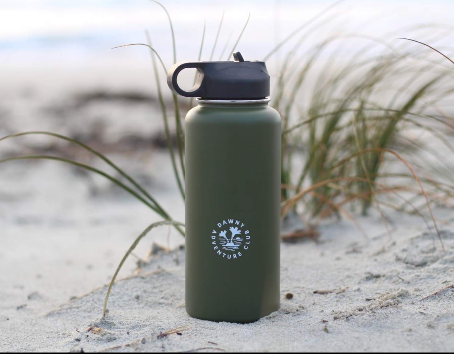 1L reusable water cooler standing on sand dunes